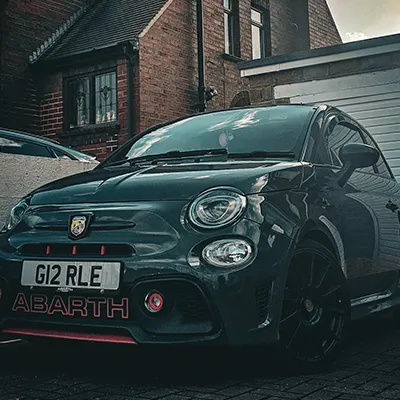 A small car parked in front of a house.