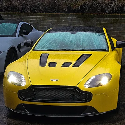 A yellow sports car parked next to a white sports car.