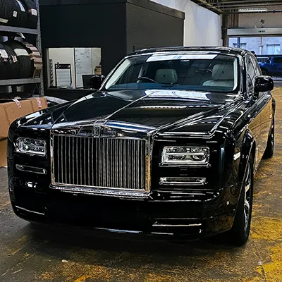 A black rolls royce parked in a garage.