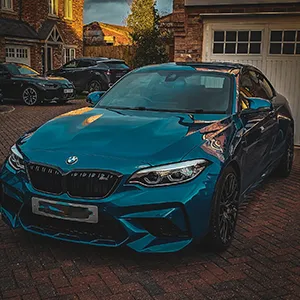 a blue car parked in front of a house