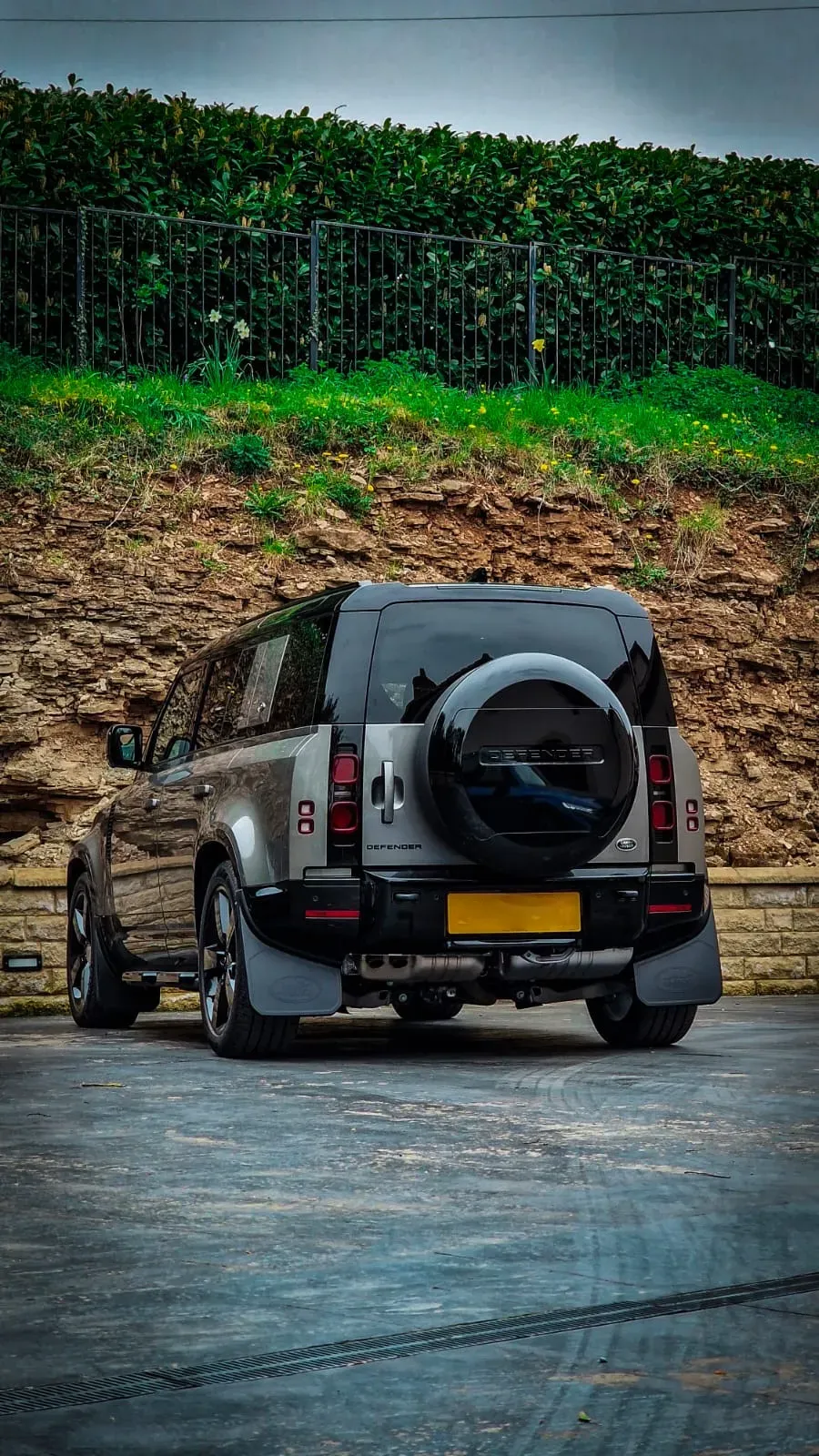 A car parked in a parking lot next to a hill.