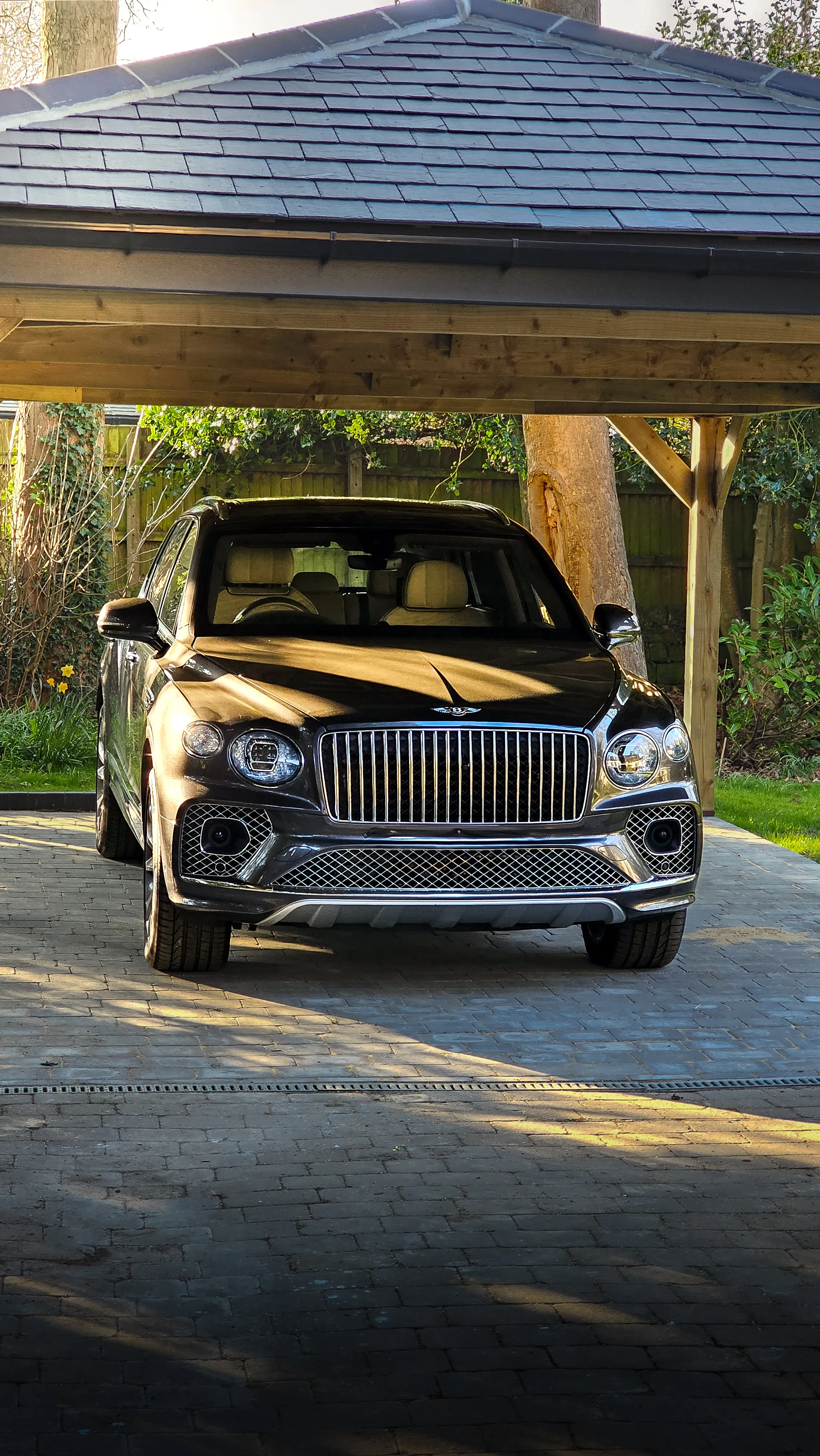 A car parked in a driveway under a covered area.