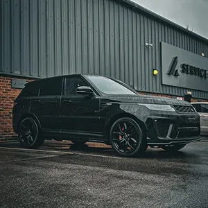 a black range rover parked in front of a building