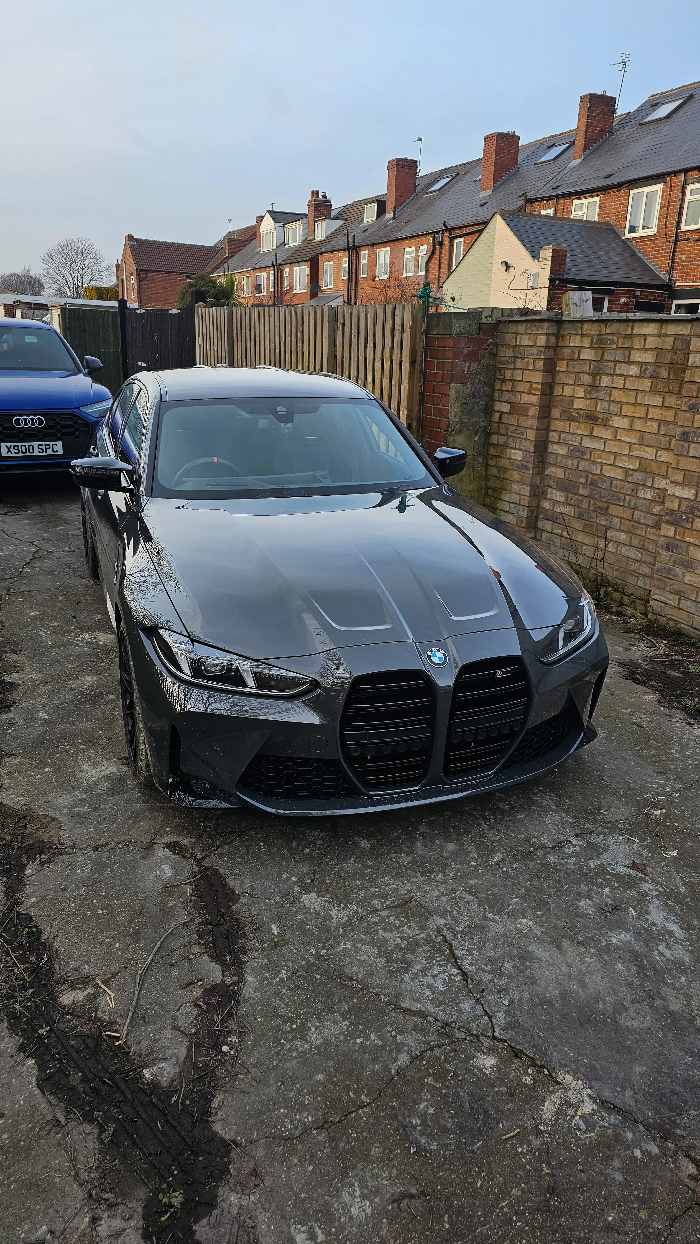 A black sports car parked next to a blue car.