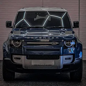 A blue truck parked in front of a garage.