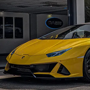 a yellow sports car parked in front of a building