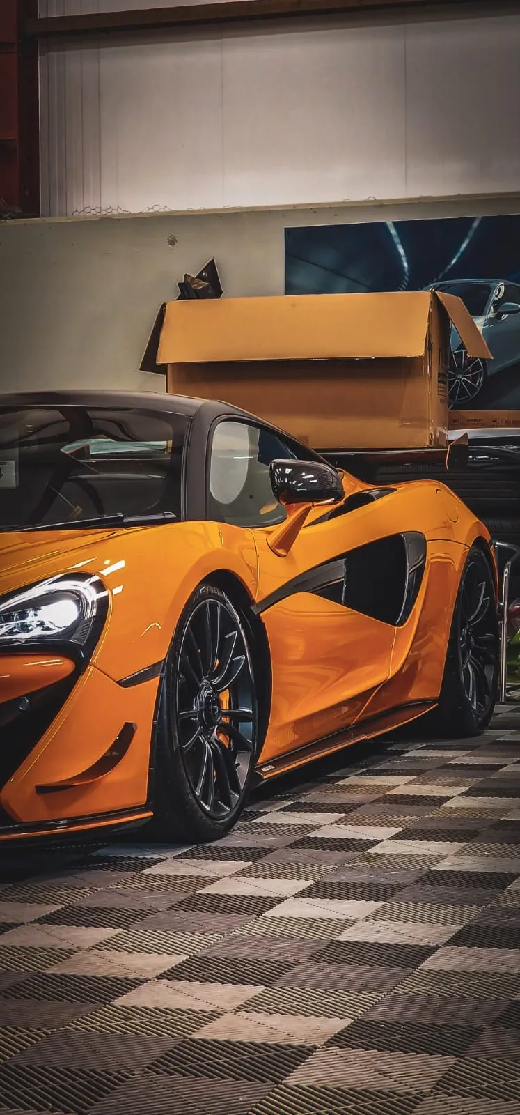An orange sports car parked in a garage.
