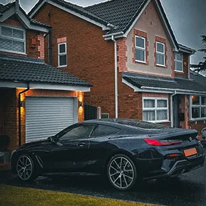 A black sports car parked in front of a house.