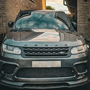 A grey range rover parked in front of a brick building.
