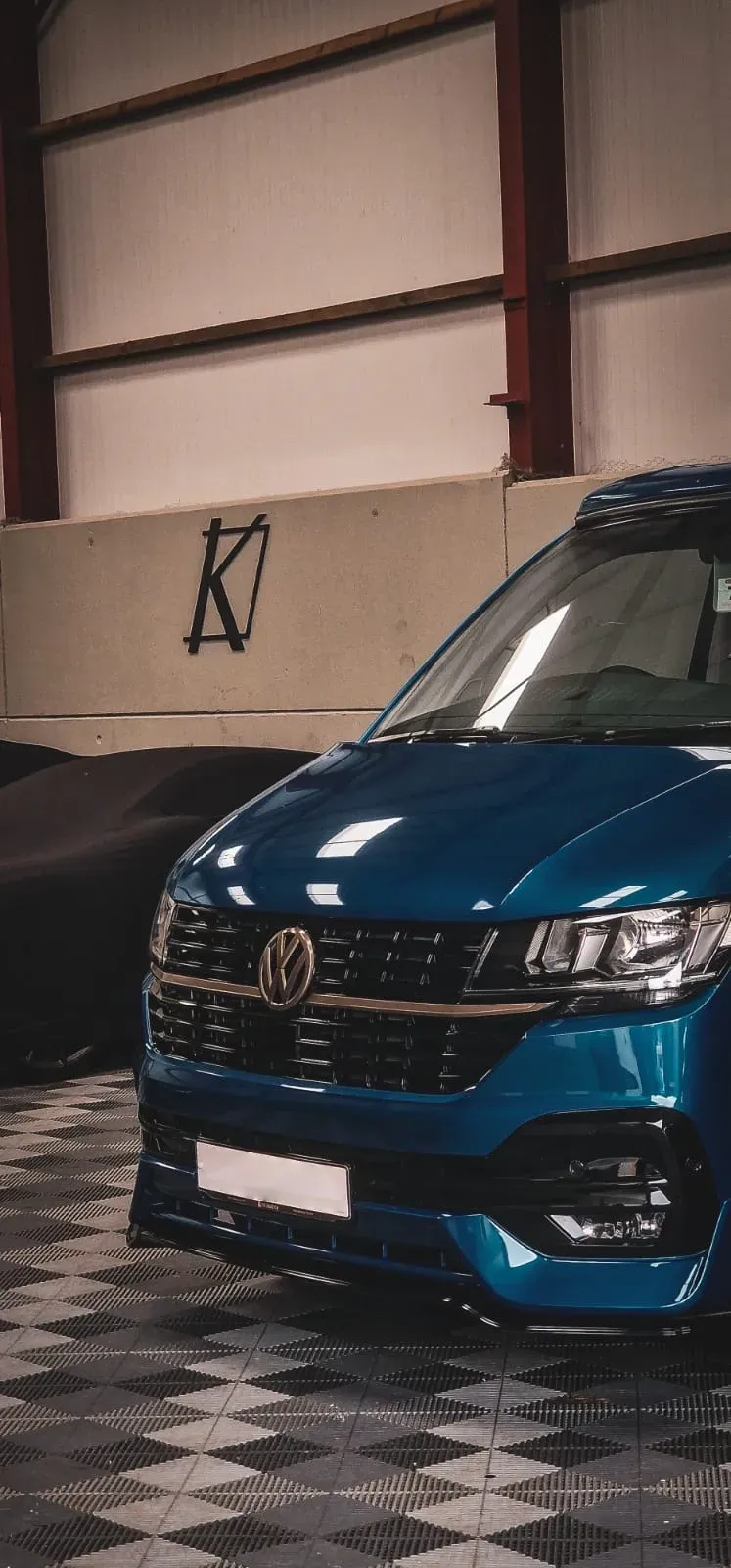 A blue car is parked in a garage.
